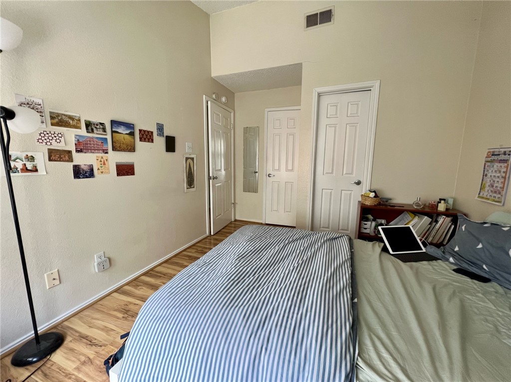 2706 Salado Street, Unit 302 Austin, TX 78705 - Photo 9 of 10 a bedroom with a bed and a refrigerator