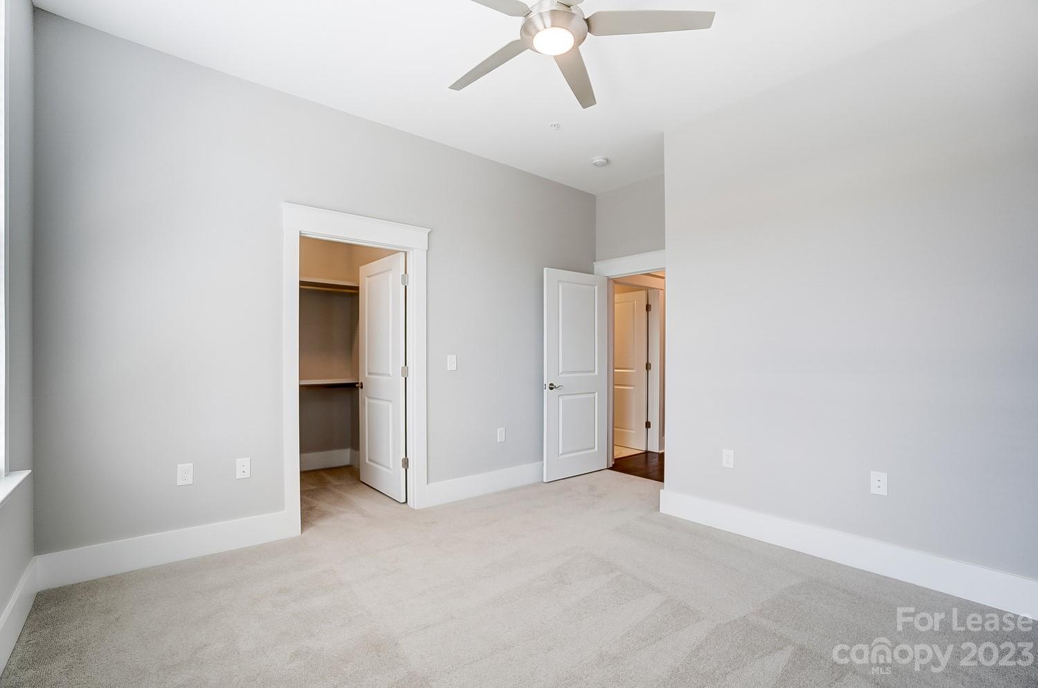 830 Providence Road, Unit 104 Charlotte, NC 28207 - Photo 15 of 21 an empty room with a ceiling fan and carpet