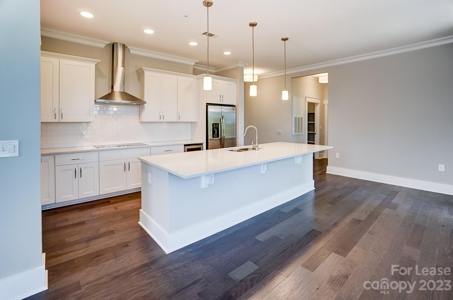 830 Providence Road, Unit 104 Charlotte, NC 28207 - Photo 6 of 21 a large kitchen with stainless steel appliances a large counter top a sink a refrigerator and a window
