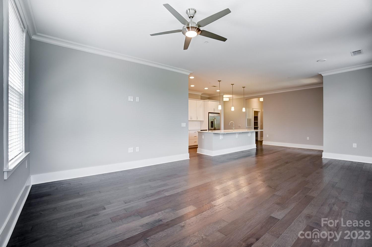 830 Providence Road, Unit 104 Charlotte, NC 28207 - Photo 9 of 21 a view of a livingroom with a ceiling fan and wooden floor