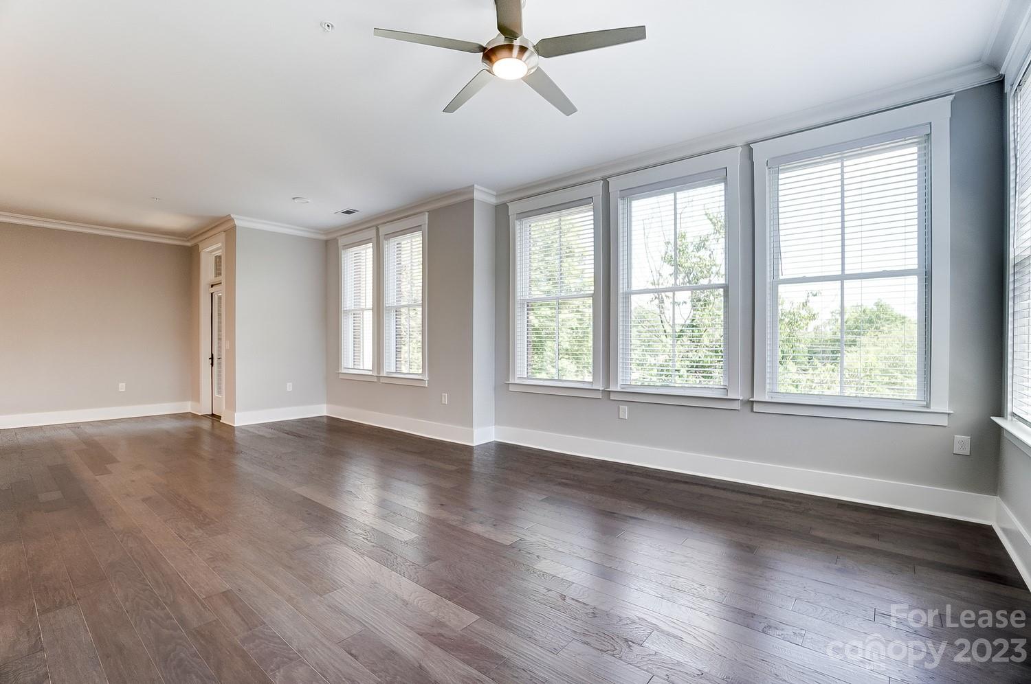 830 Providence Road, Unit 104 Charlotte, NC 28207 - Photo 10 of 21 a view of an empty room with wooden floor and a window