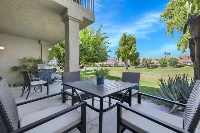 a view of a chairs and table in patio with a lake view