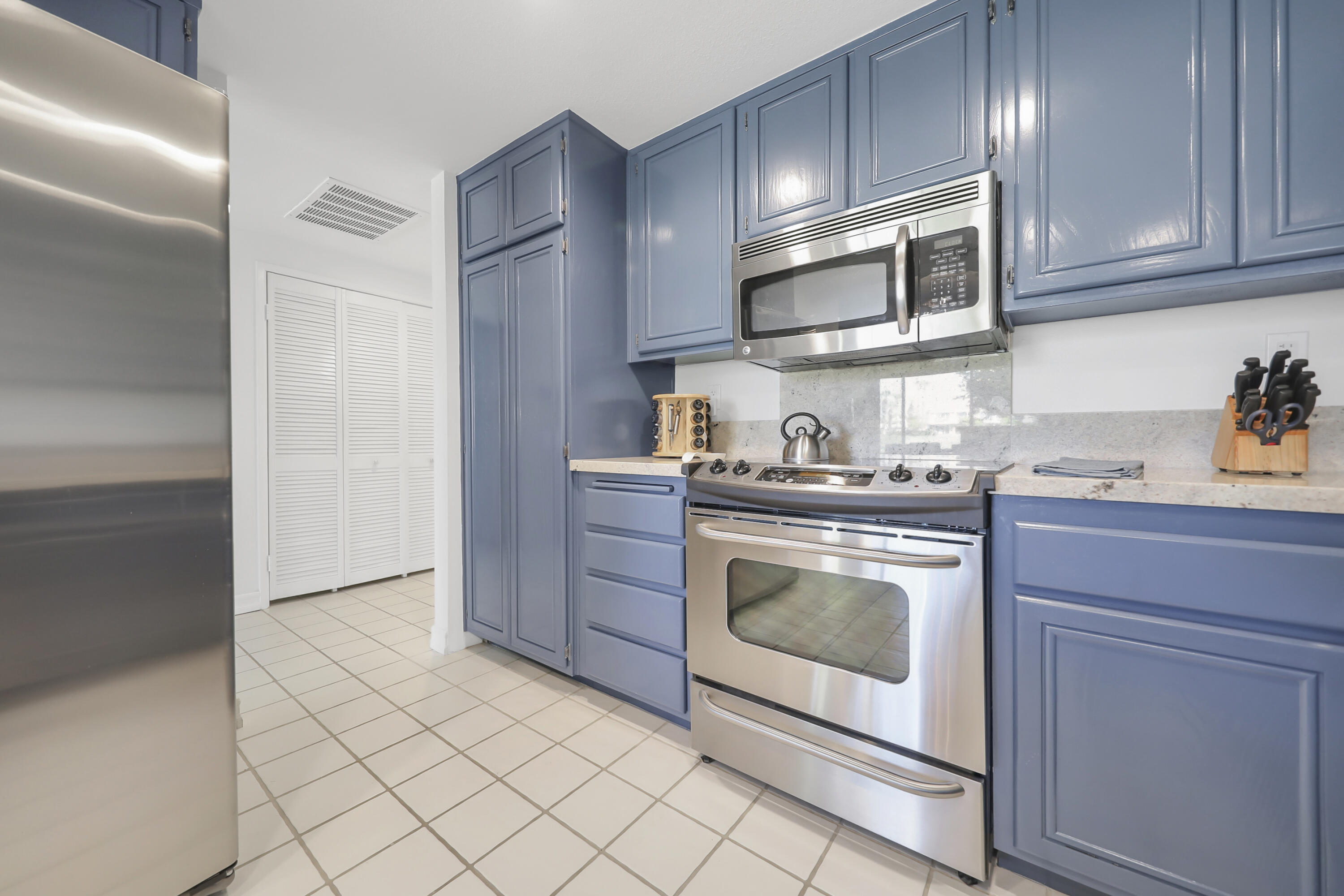 55359 Winged Foot La Quinta, CA 92253 - Photo 11 of 22 a kitchen with stainless steel appliances granite countertop a stove a microwave and a refrigerator