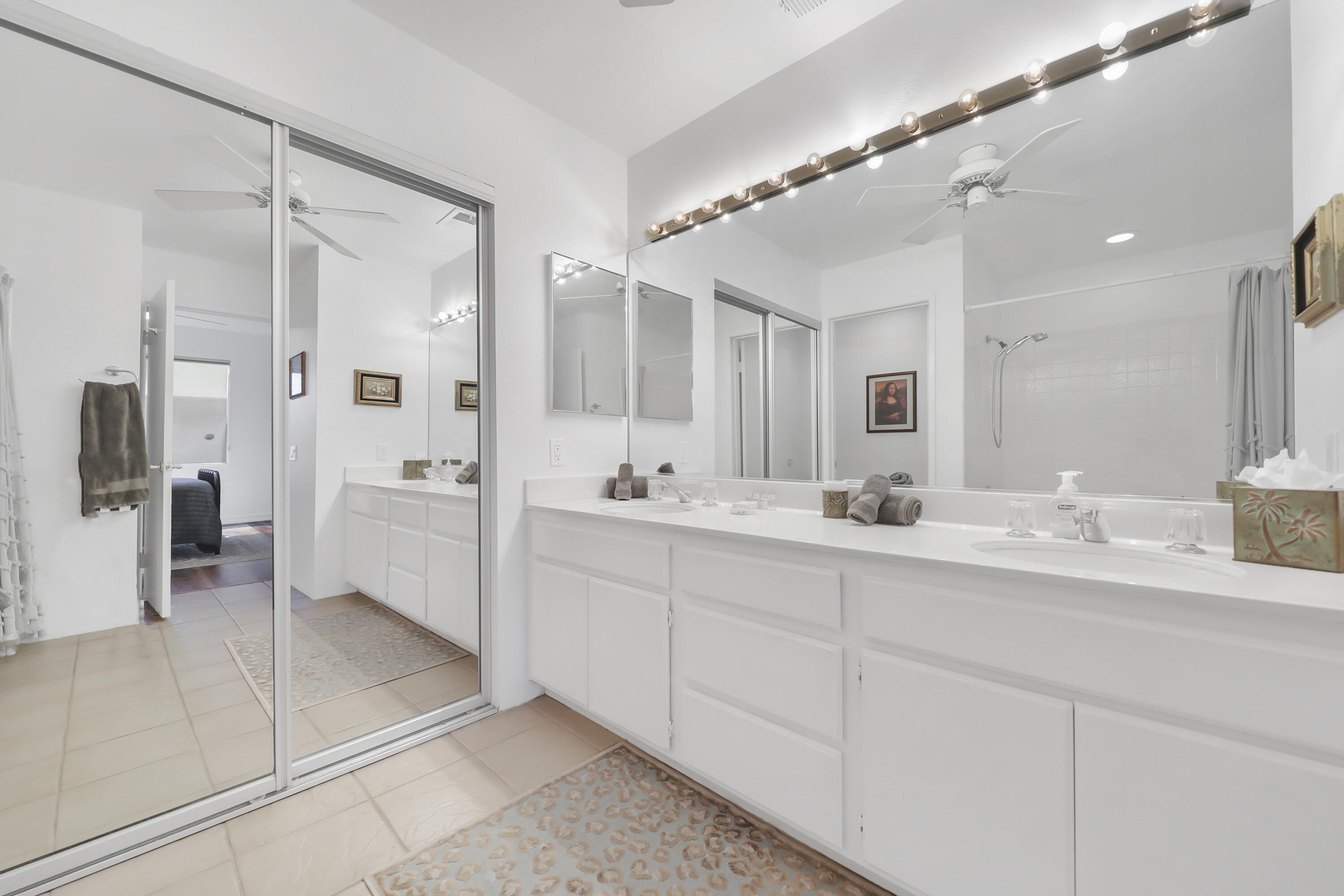 55359 Winged Foot La Quinta, CA 92253 - Photo 17 of 22 a bathroom with a double vanity sink a mirror and a shower