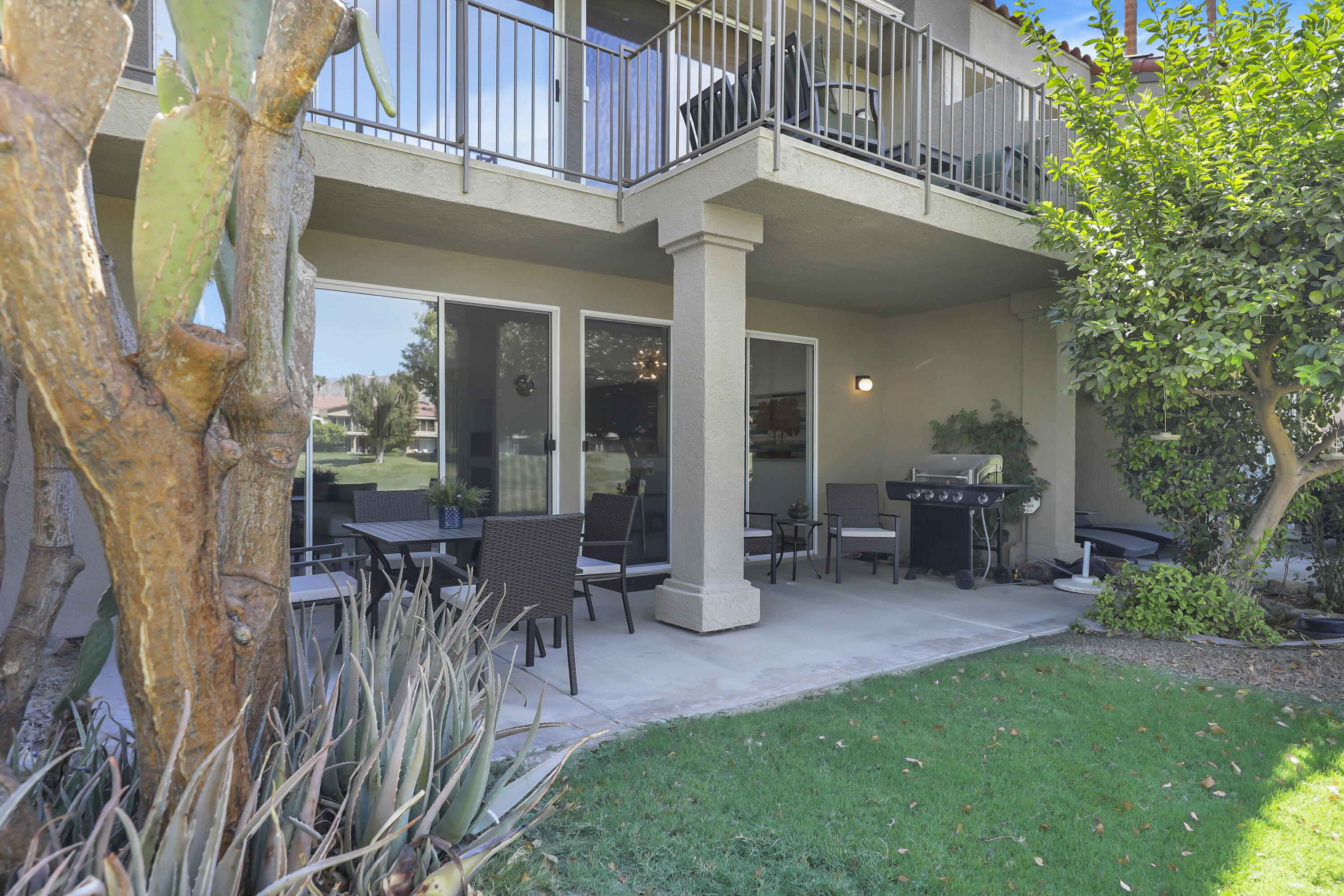 55359 Winged Foot La Quinta, CA 92253 - Photo 18 of 22 a view of a patio with table and chairs potted plants and floor to ceiling window