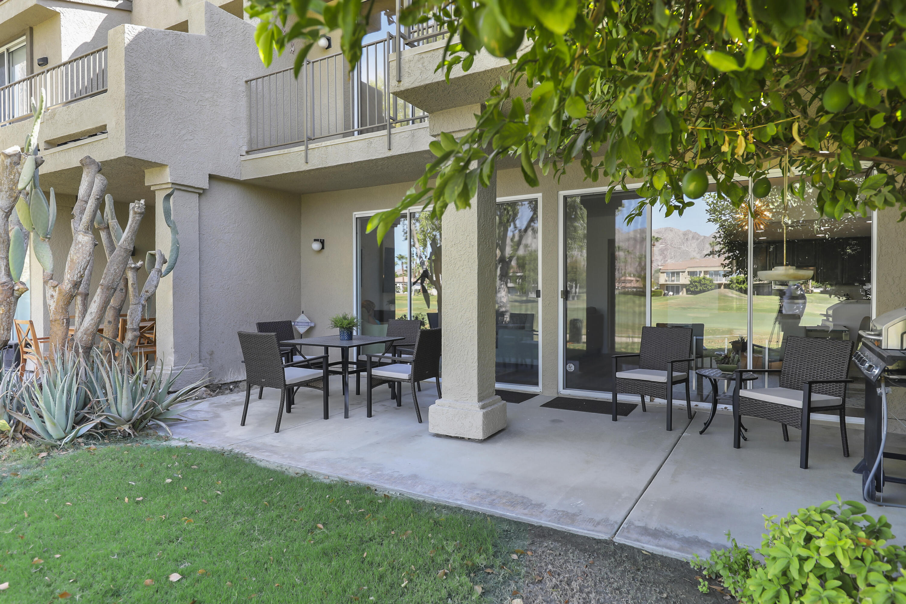 55359 Winged Foot La Quinta, CA 92253 - Photo 2 of 22 a view of a patio with table and chairs potted plants and a large tree