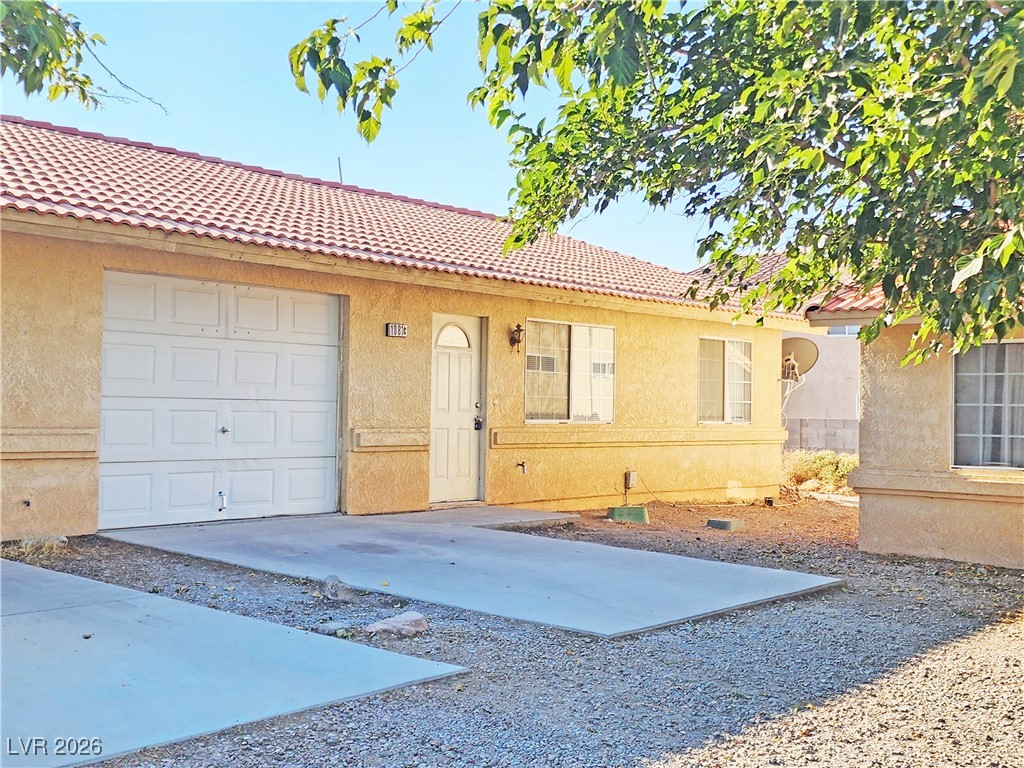 View of front of property featuring stucco siding and a tiled roof