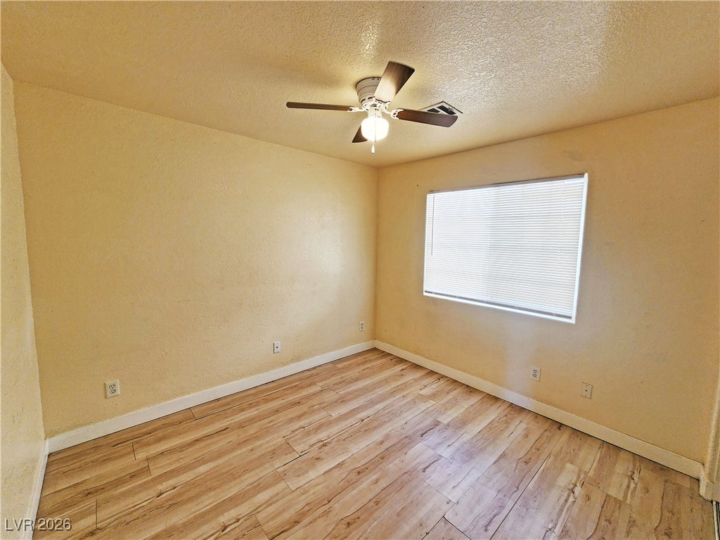 1081 Marne Court, Unit C Pahrump, NV 89048 - Photo 13 of 22 Empty room with light wood-style flooring, a textured ceiling, and a ceiling fan