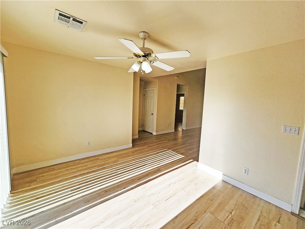 1081 Marne Court, Unit C Pahrump, NV 89048 - Photo 6 of 22 Empty room with light wood-type flooring, a ceiling fan, and a textured ceiling