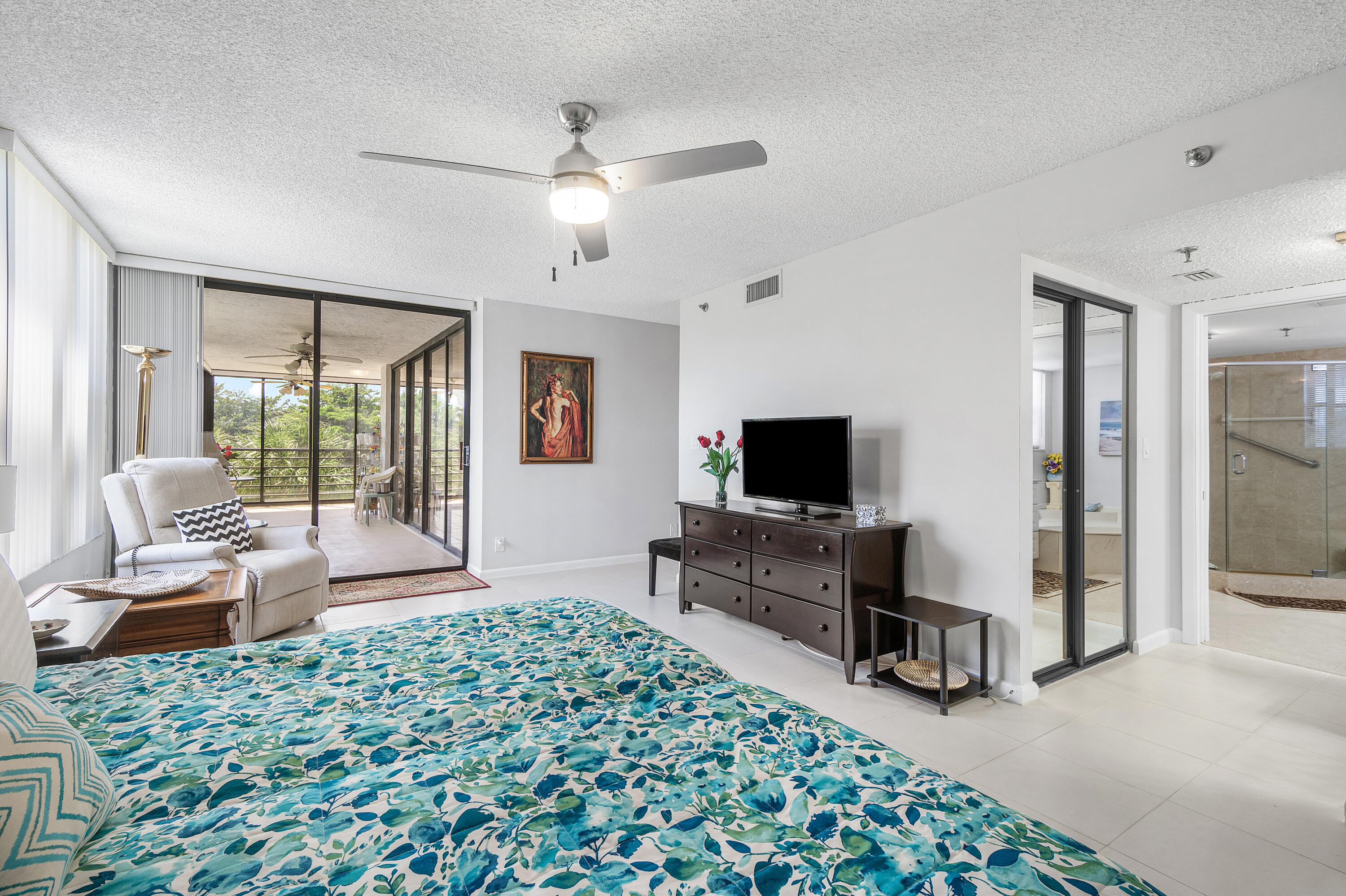 7572 Regency Lake Drive, Unit 401 Boca Raton, FL 33433 - Photo 16 of 28 a living room with furniture and a flat screen tv
