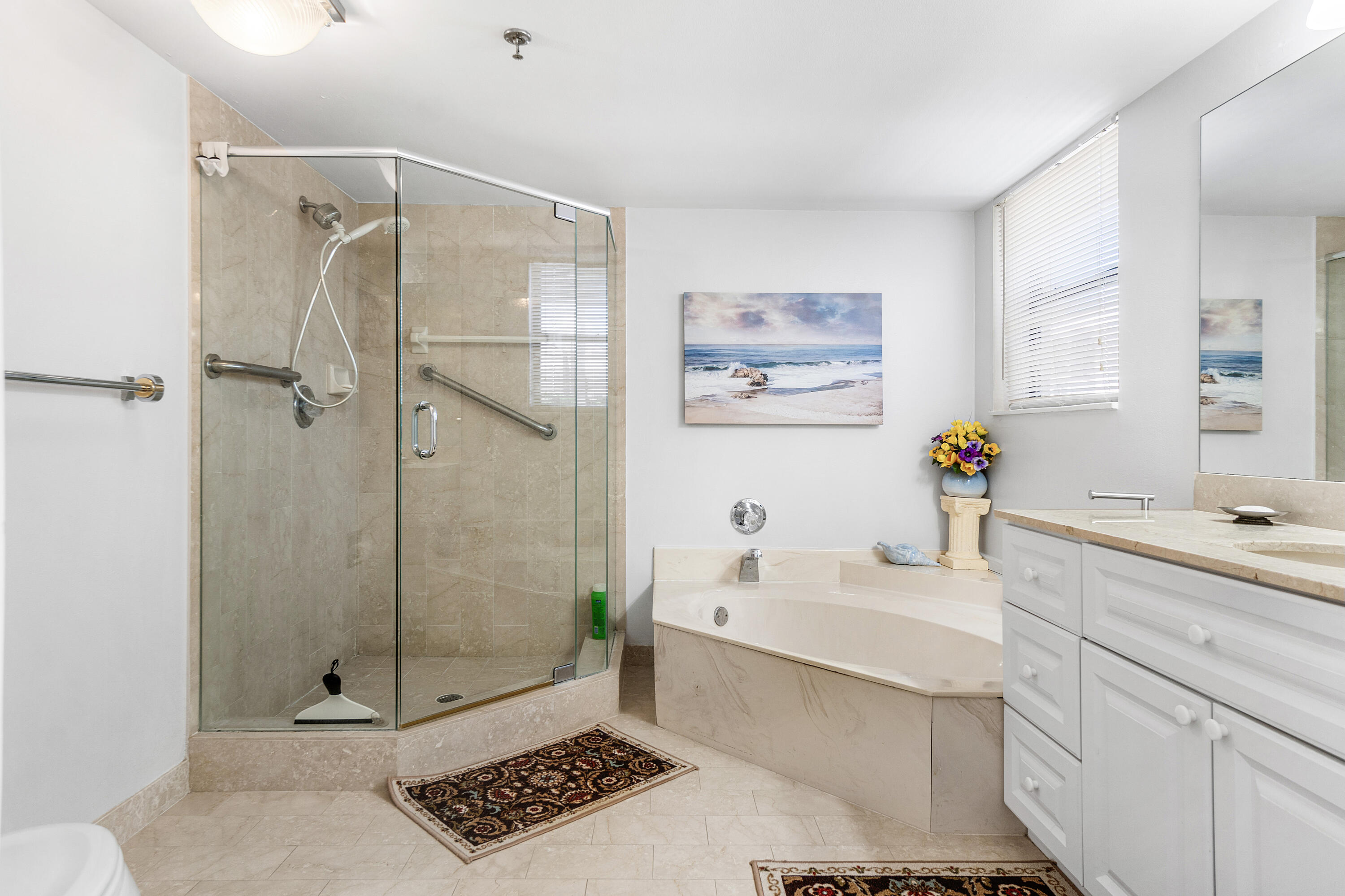 7572 Regency Lake Drive, Unit 401 Boca Raton, FL 33433 - Photo 18 of 28 a bathroom with a sink a mirror and a shower