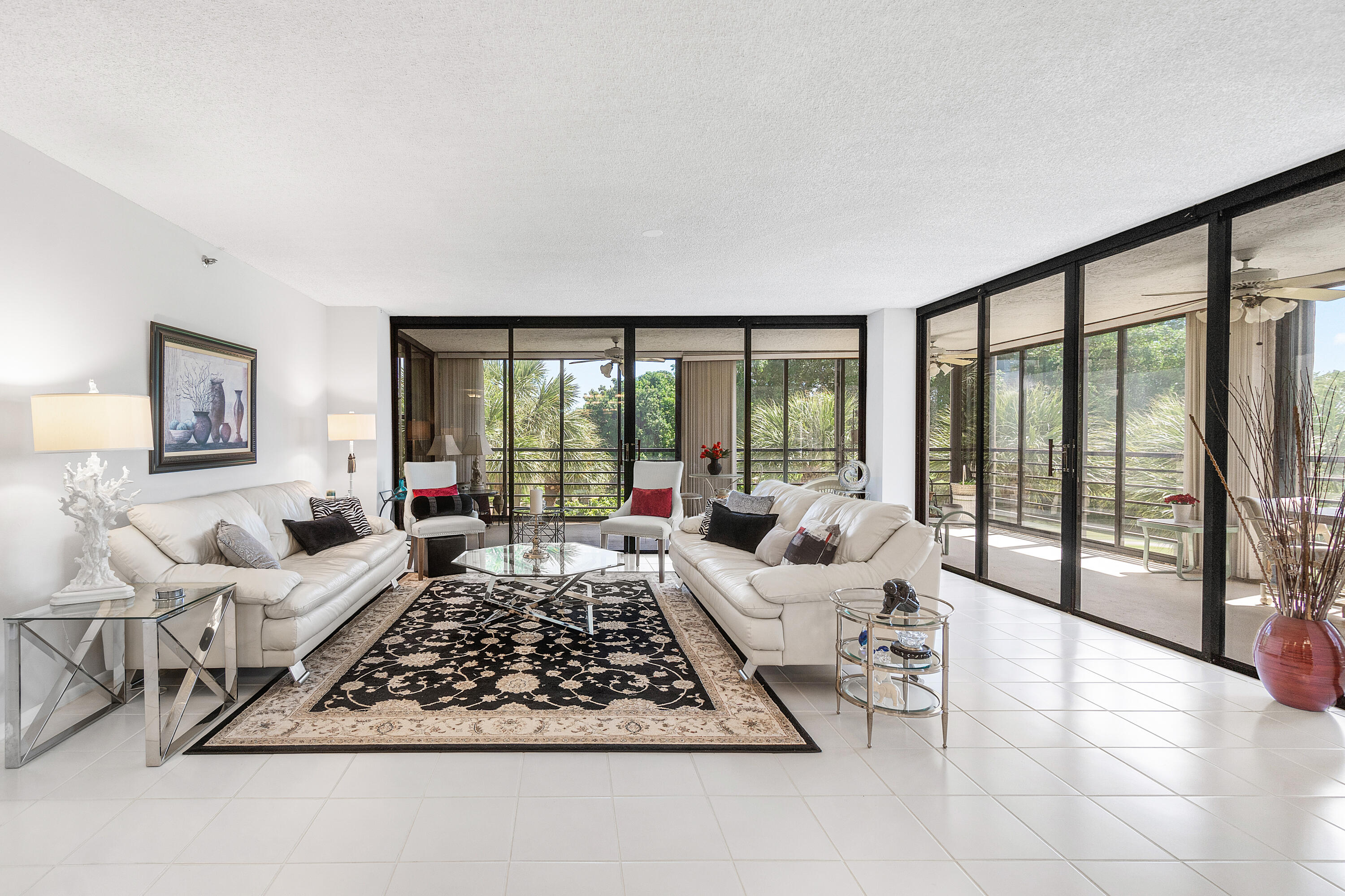 7572 Regency Lake Drive, Unit 401 Boca Raton, FL 33433 - Photo 2 of 28 a living room with furniture floor to ceiling window and a rug