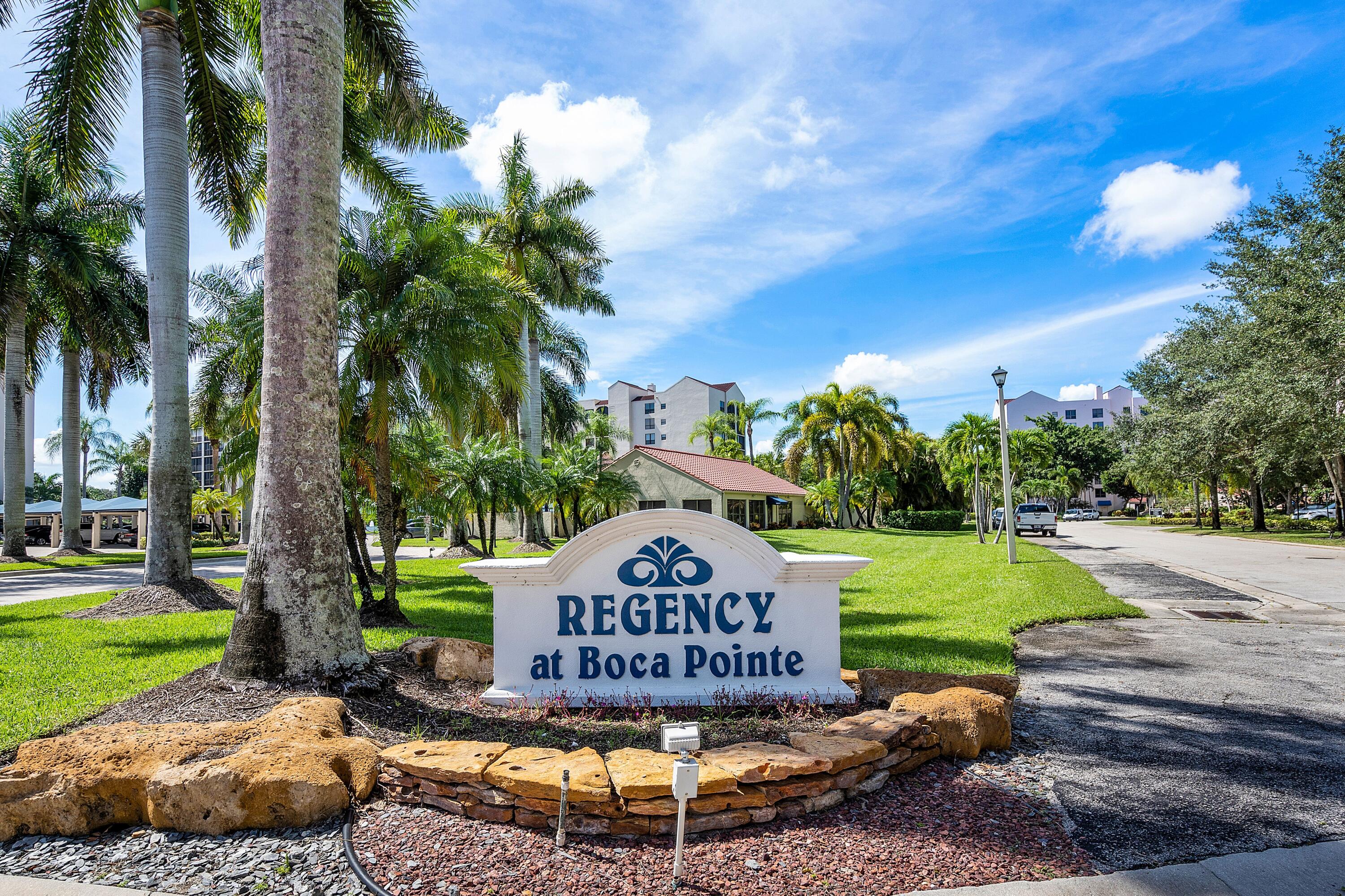 7572 Regency Lake Drive, Unit 401 Boca Raton, FL 33433 - Photo 23 of 28 a sign that is sitting on a road with a big yard