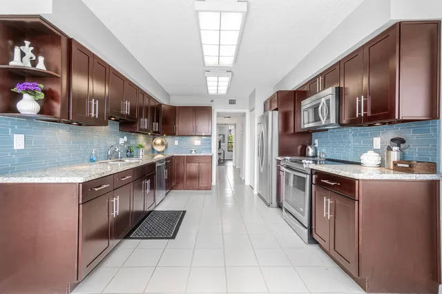 a kitchen with stainless steel appliances granite countertop a sink stove and refrigerator