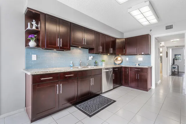 a kitchen with stainless steel appliances granite countertop a stove a sink and a refrigerator