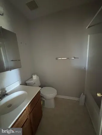 a white toilet sitting next to a bathroom sink