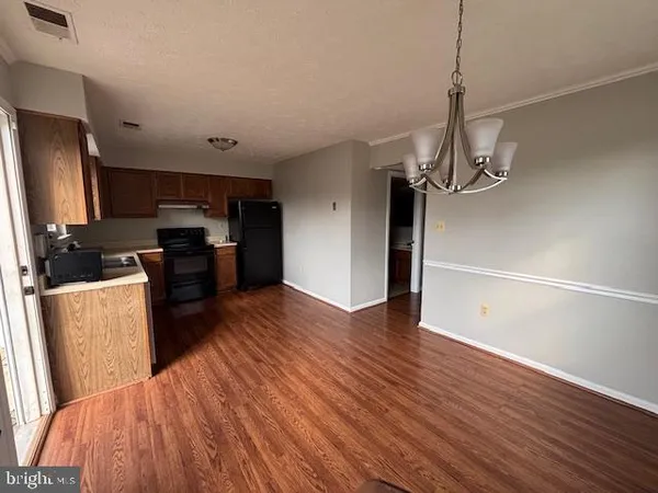 a view of a kitchen with stove and wooden floor