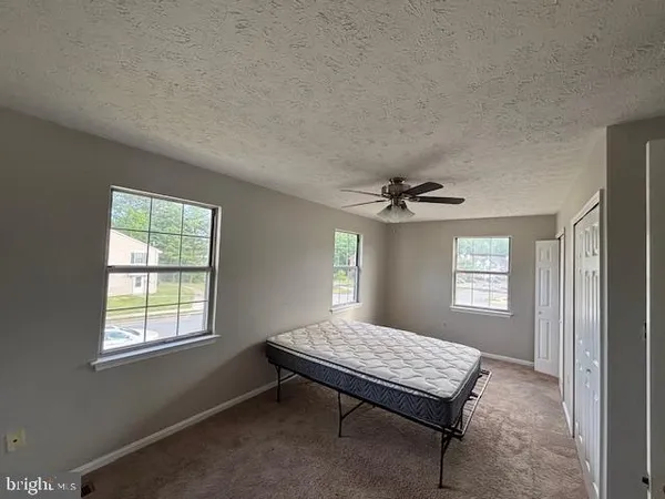 a spacious bedroom with a bed and a window