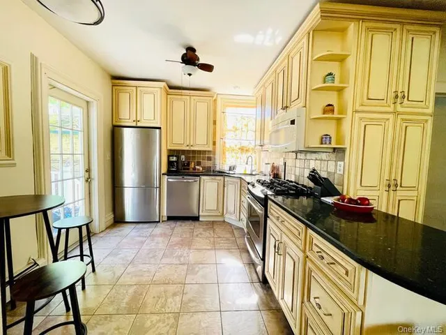 a kitchen with stainless steel appliances granite countertop a sink a stove and a refrigerator