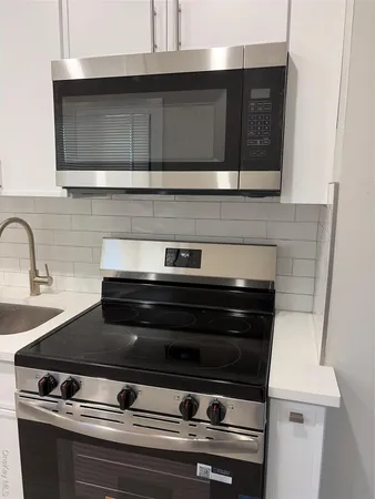 a stove top oven sitting inside of a kitchen