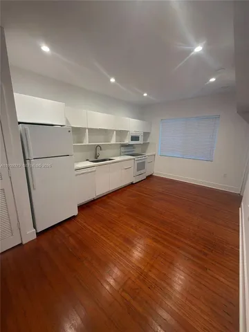 a kitchen with kitchen island a sink and wooden floor
