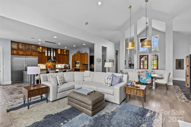 a living room with furniture kitchen view and a chandelier