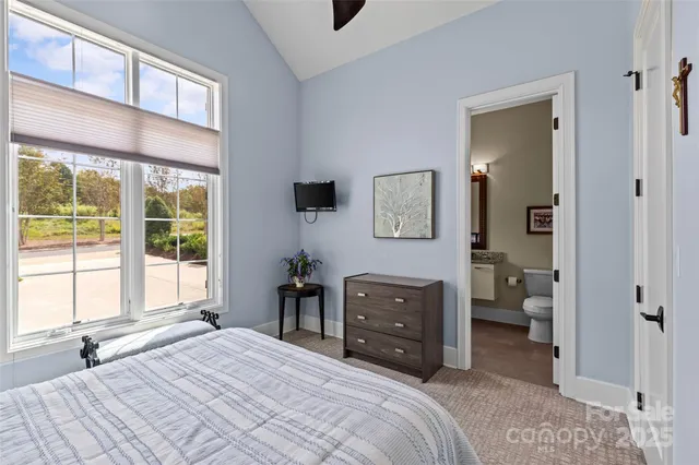 a bathroom with a granite countertop sink a toilet a mirror and shower