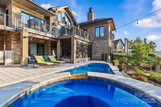 a view of a house with pool and sitting area