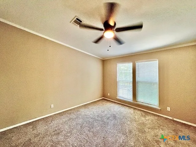 an empty room with fan and windows