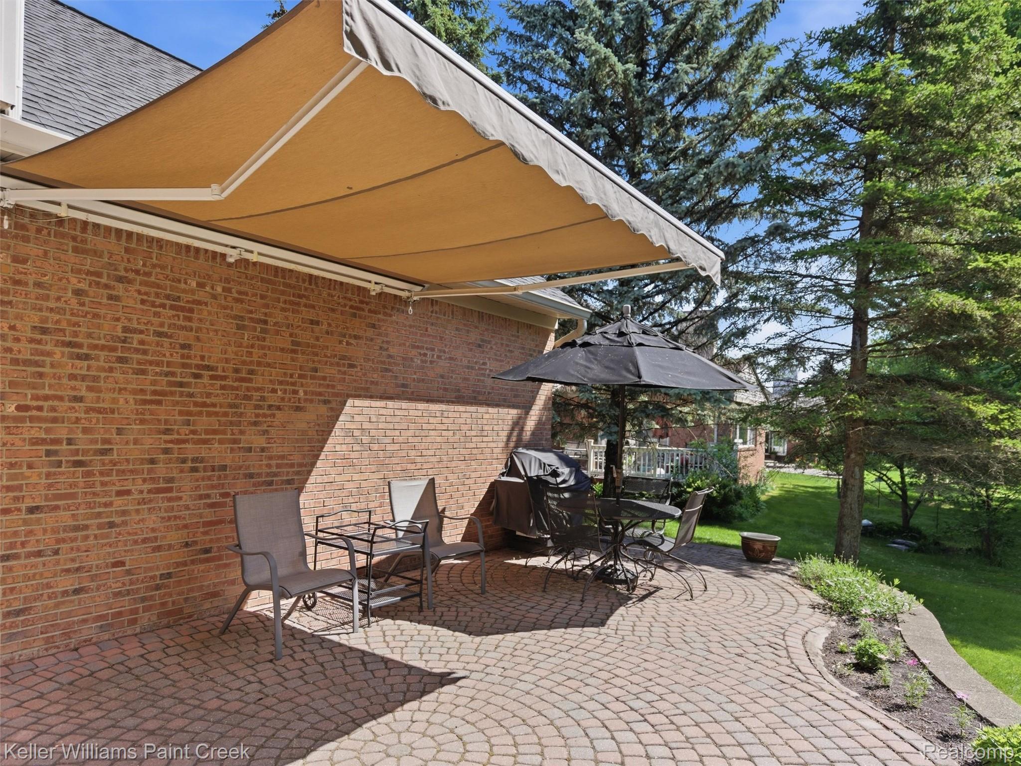 2842 Manorwood Road Troy, MI 48085 - Photo 62 of 72 Brick exterior featuring a retractable awning over a paver patio