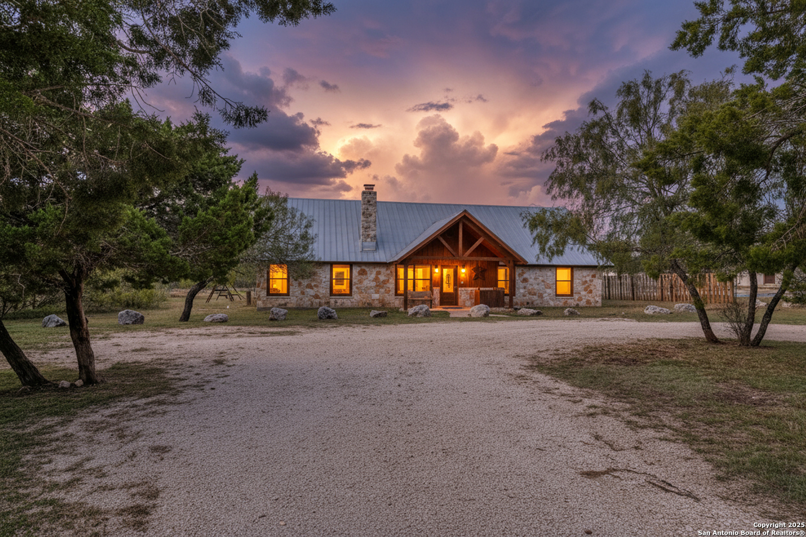 38 Mountain Laurel Lane Concan, TX 78838 - Photo 3 of 48 a view of a large house with large trees and wooden fence