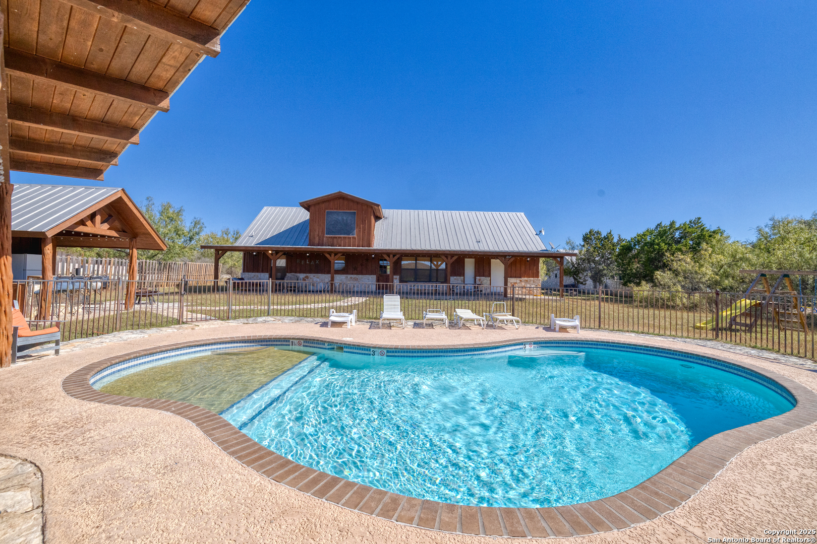 38 Mountain Laurel Lane Concan, TX 78838 - Photo 9 of 48 a view of a swimming pool with couches chairs under an umbrella