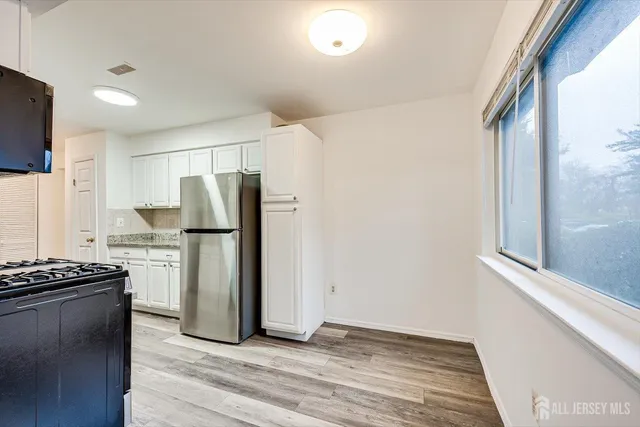 a kitchen with a refrigerator and a stove top oven
