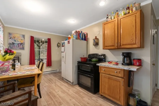 a view of a kitchen with fridge and wooden floor