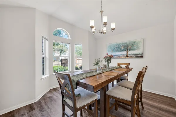 a view of a dining room with furniture a chandelier and wooden floor