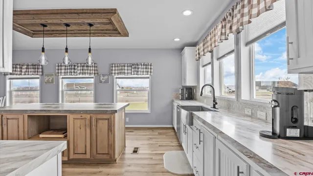a view of a workspace with furniture and a window