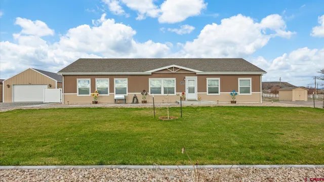 a kitchen with stainless steel appliances granite countertop a refrigerator a sink dishwasher a stove and white cabinets with wooden floor