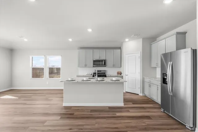 a kitchen with stainless steel appliances a refrigerator and a stove top oven
