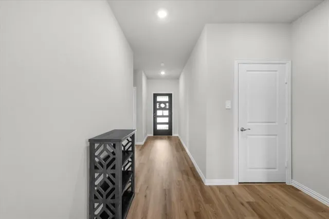 a view of a hallway with wooden floor and closet