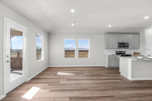a view of kitchen with granite countertop cabinets and refrigerator