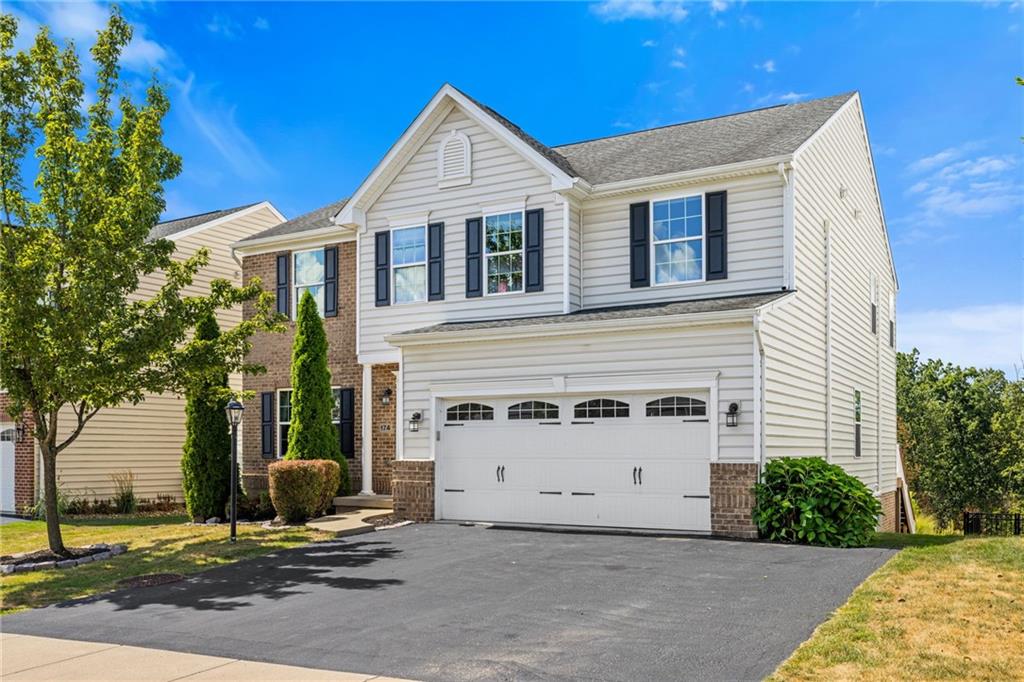 a view of a white house with a yard and a large tree