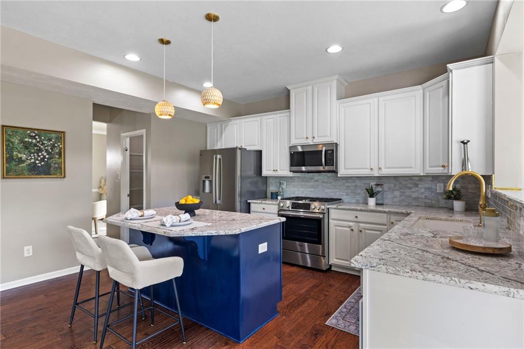 174 Cimarron Drive Coraopolis, PA 15108 - Photo 20 of 50 a kitchen with stainless steel appliances granite countertop a kitchen island a stove a table and chairs in it
