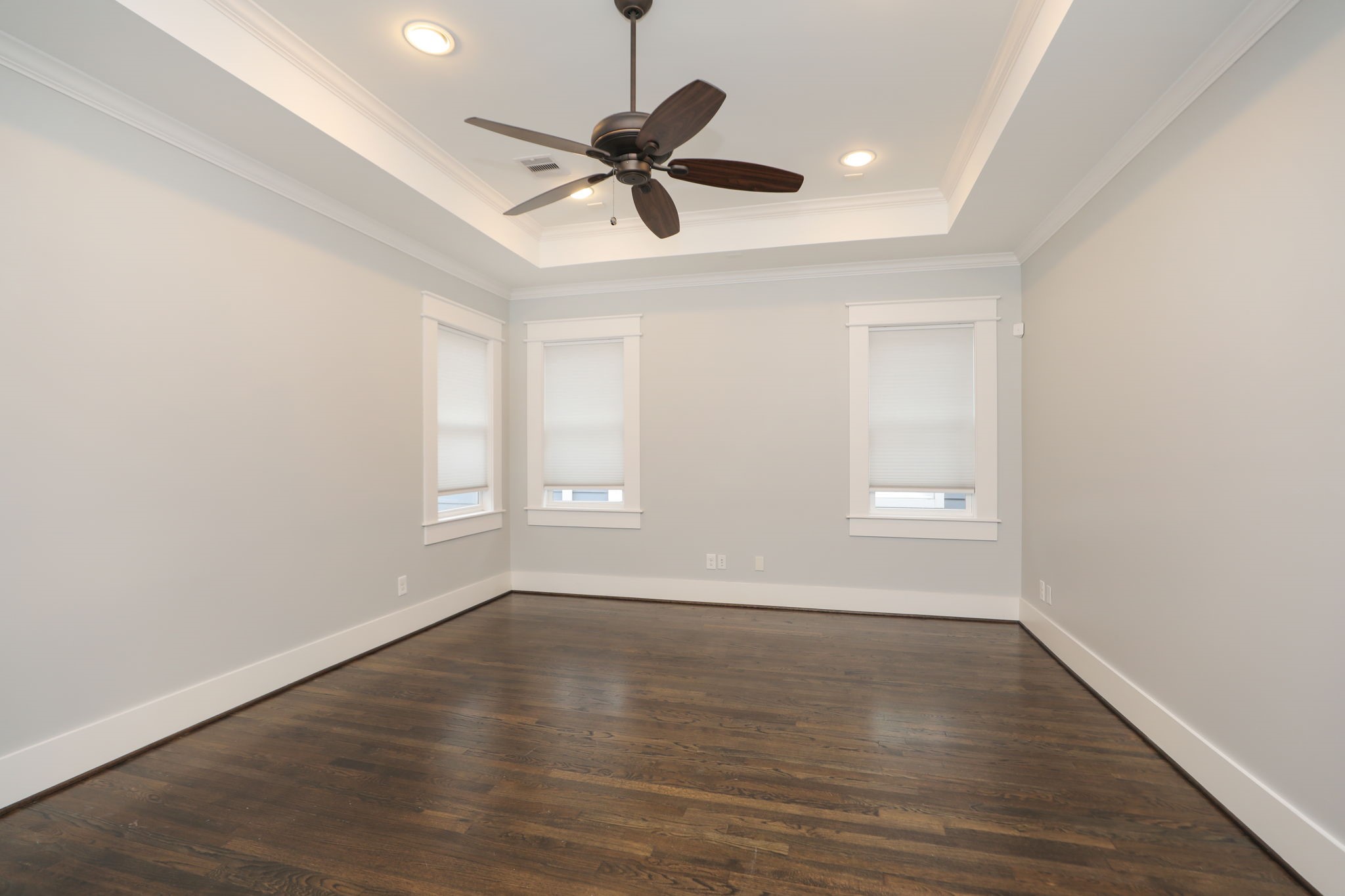 907 East 25th Street Houston, TX 77009 - Photo 21 of 32 Huge game room upstairs with hardwood floors and tray ceiling with ceiling fan.