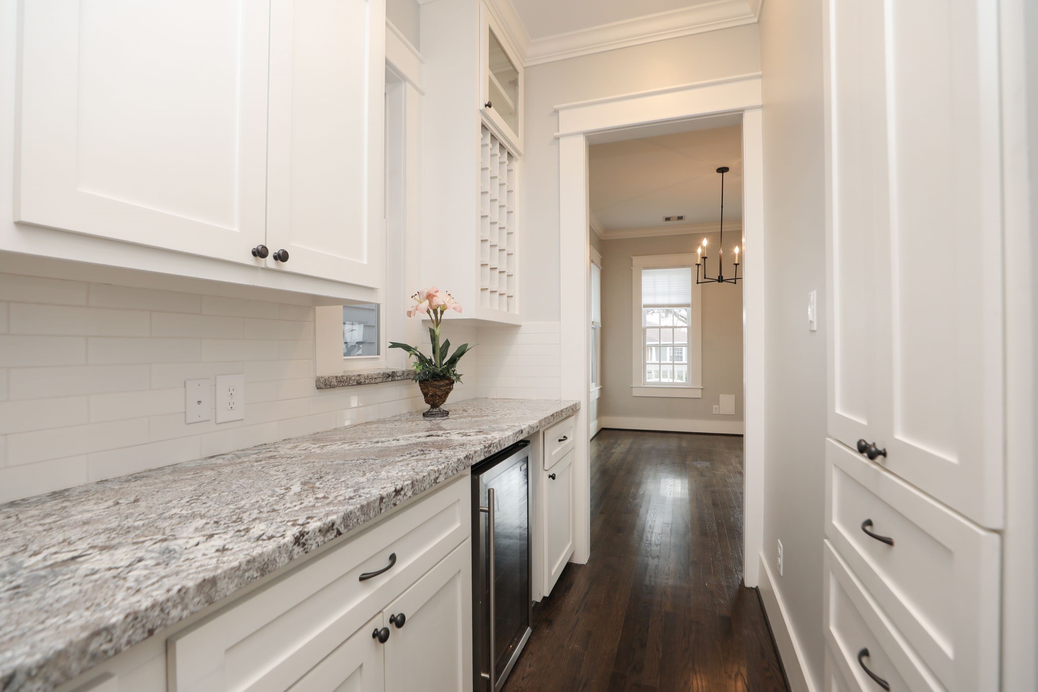 907 East 25th Street Houston, TX 77009 - Photo 5 of 32 Head to the kitchen from dining area and see the built in wine storage and wine cabinet as well as extra cabinets for storage.