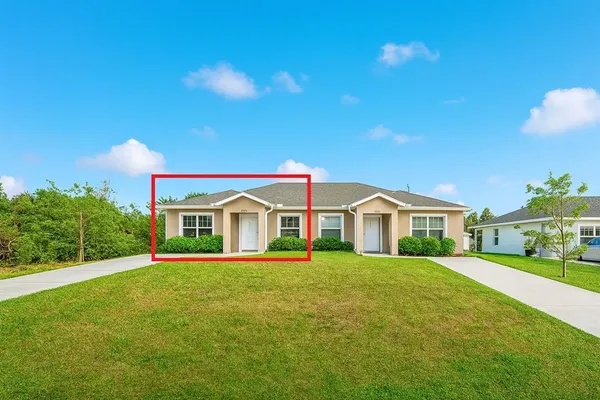 a front view of a house with a yard and trees
