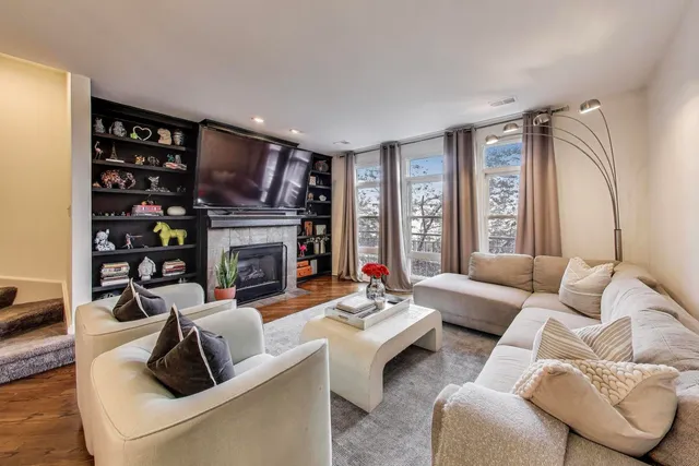 a living room with furniture flowers and a view of kitchen