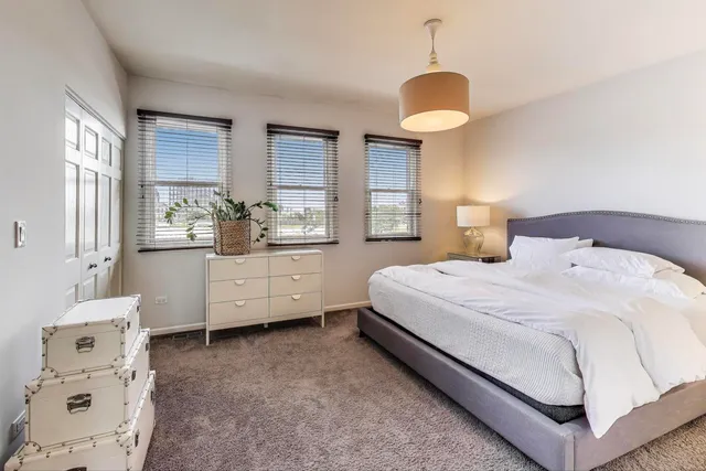 a bedroom with a bed and a flat tv screen on dresser