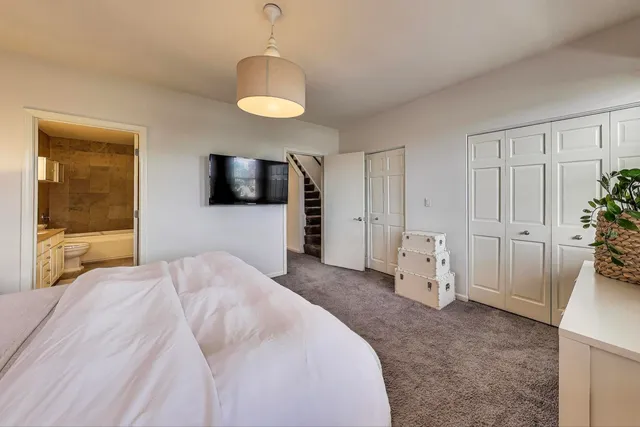 a bathroom with a double vanity sink a toilet a mirror and shower