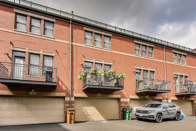 a view of a balcony with dining table and chairs with potted plants
