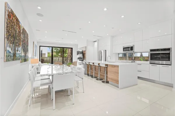 a kitchen with stainless steel appliances kitchen island granite top and refrigerator